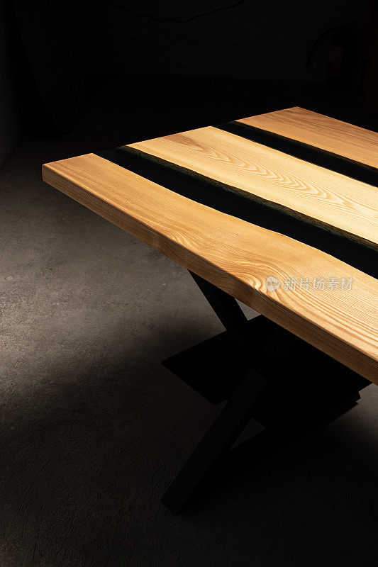 桌子被环氧树脂和清漆覆盖。豪华优质木材加工。深色背景的木桌。黑河用环氧树脂制成。