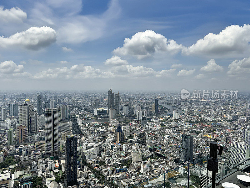 素坤逸市中心，曼谷市中心，泰国城市景观摩天大楼天际线从玻璃安全屏障后，朝披耶河，线性城市化，阳光明媚的蓝天与蓬松的白云，高架视图