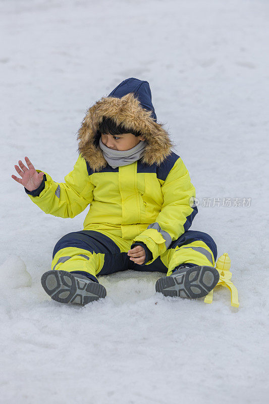 孩子们在雪中玩耍。冬天，穿着滑雪服的亚洲孩子在扔雪。快乐的童年。江原道，韩国