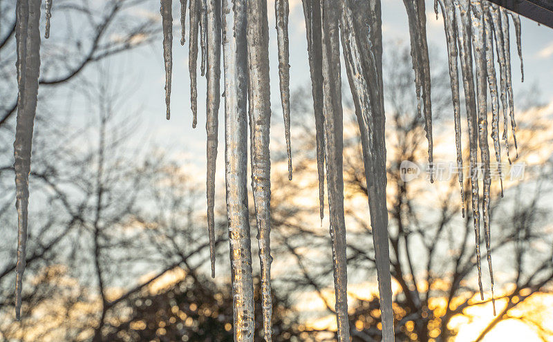 在一个下雪的冬天，屋顶上的大冰柱正在融化