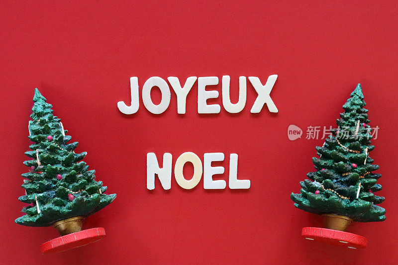 自制DIY简易圣诞贺卡设计的图像，红色背景上剪出白色字母，模型圣诞树，手工制作的节日圣诞贺卡，法语圣诞祝词