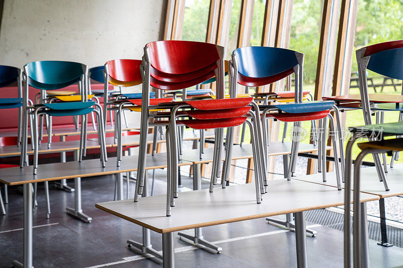 空教室里的桌子上空着彩色椅子