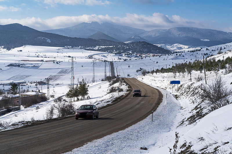 在积雪覆盖的山区地形中蜿蜒的高速公路