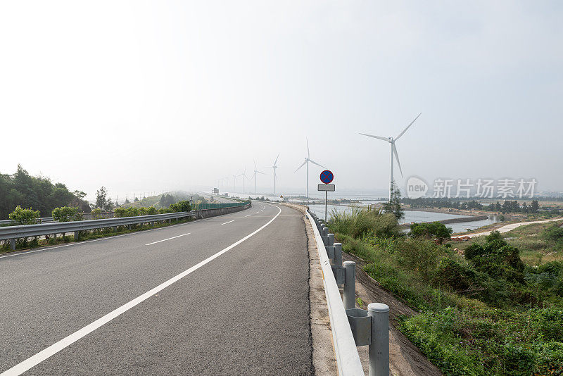 空旷的高速公路和整洁的风力涡轮机