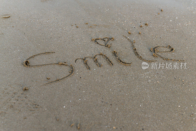 微笑留言手写在沙滩上。