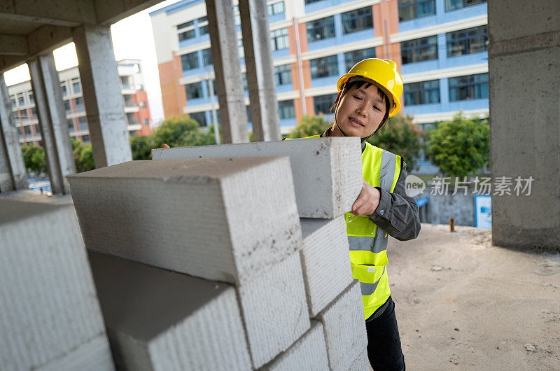 一位女性蓝领工人正在建筑工地工作