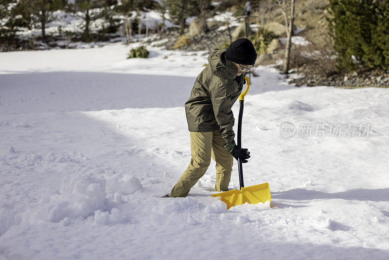 男孩在家里铲雪