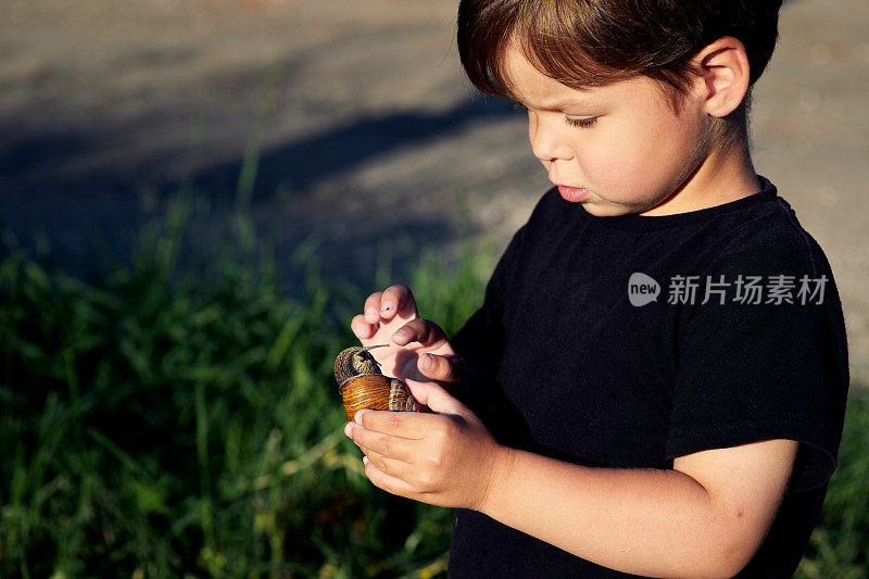 一个小孩抱着一只蜗牛