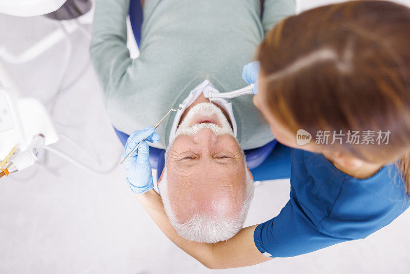 牙科医生正在用牙钻修理病人的牙齿