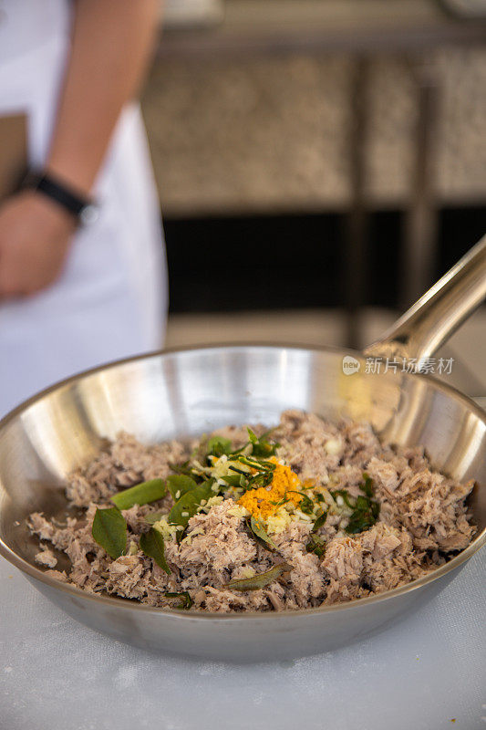 烹饪马尔代夫金枪鱼咖喱在钢锅在厨房与辣椒，咖喱叶和香料