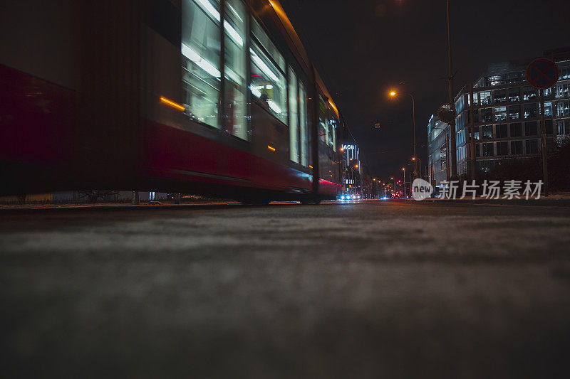 灯火通明的公共汽车在夜晚的城市街道上向前行驶