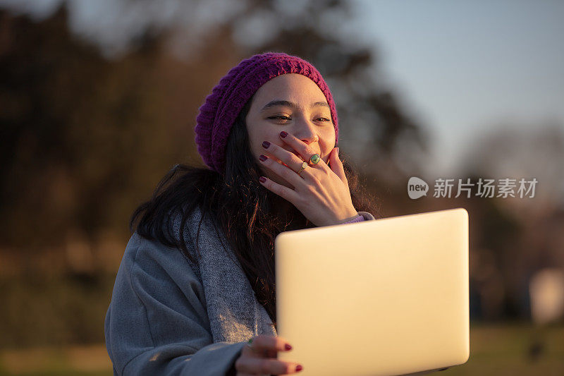 年轻的学生女孩正在外面学习。