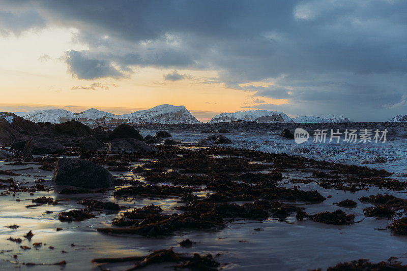 在挪威明亮的日落期间，冬季海滩的风景