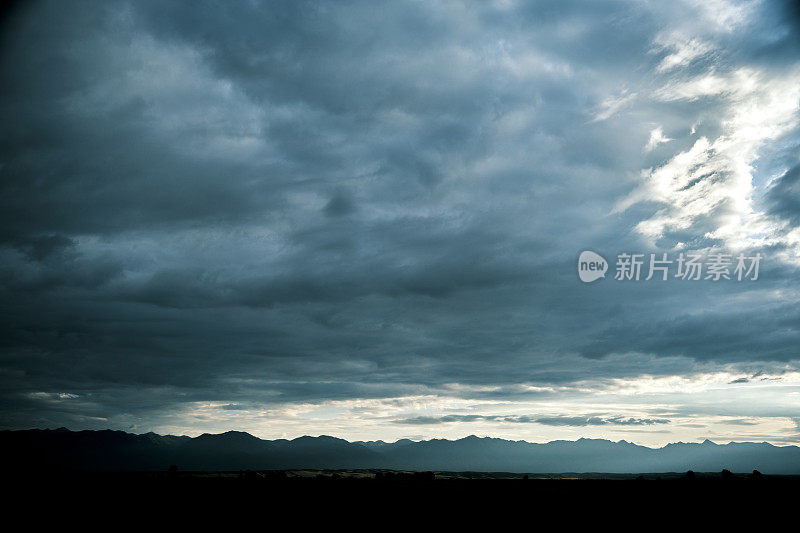 在黎明多云的天空下，地平线上的山脊