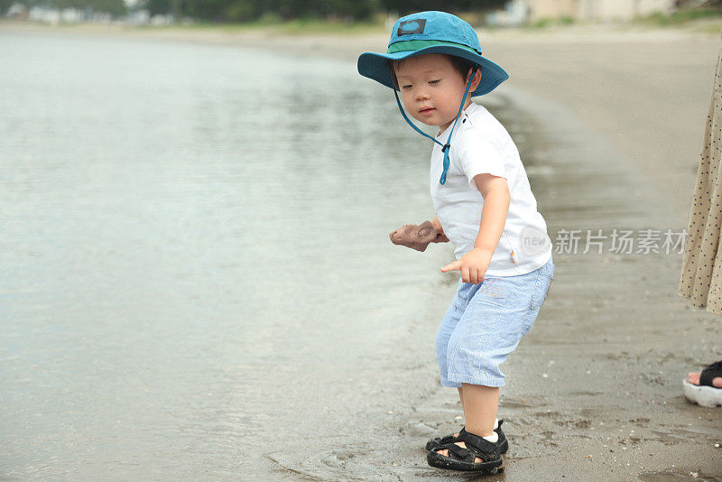 年轻的母亲和她的小儿子在海滩上玩耍