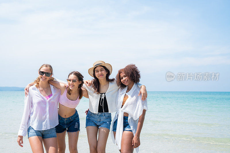快乐的青少年在海滩聚会一起在海滩上玩在一个阳光明媚的日子，海滩暑假海人的概念