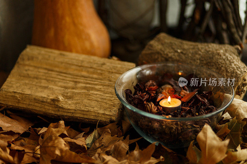 一个小的茶蜡烛，放在一个碗里，与花香一起作为一个舒适的秋天装饰
