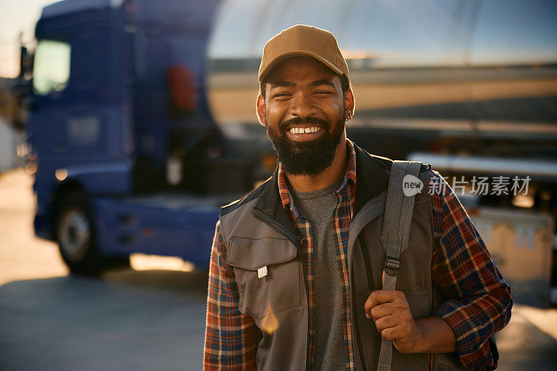 快乐的黑人职业司机在卡车停车场看着摄像头。