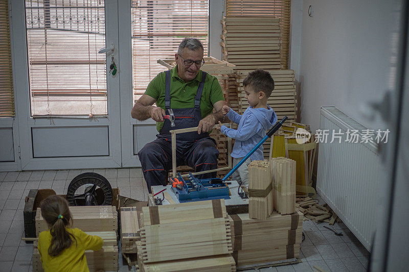 爷爷和孙子们在作坊里制作木框