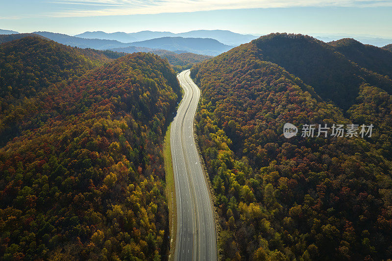 通往北卡罗来纳州阿什维尔的I-40高速公路上空无一车，这条公路穿过阿巴拉契亚山脉和黄色的秋天森林。高油价与能源危机的概念