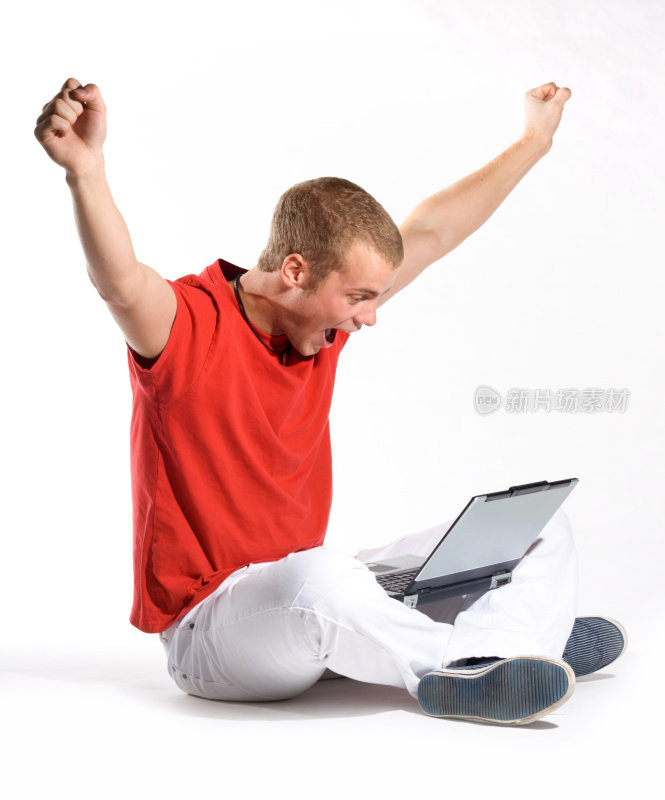 一名男子挥舞着手臂庆祝他的笔记本电脑传来的好消息