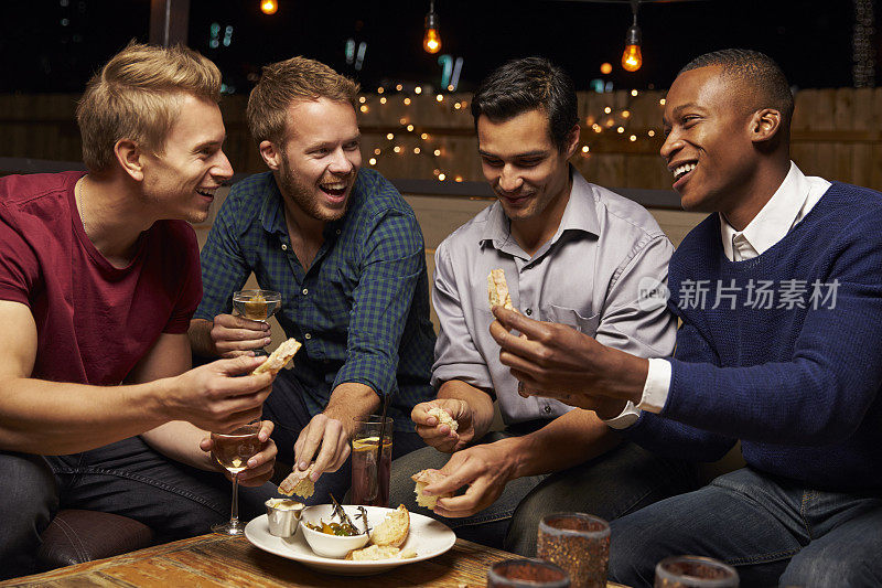 一群男性朋友在屋顶酒吧享受夜晚