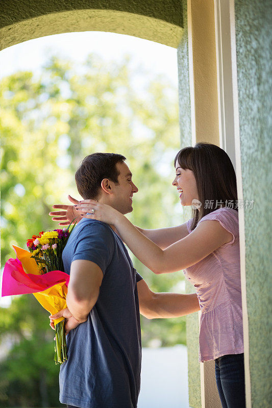 女人和男人把花藏在背后