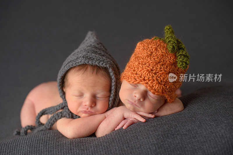刚出生的双胞胎戴着针织帽睡觉