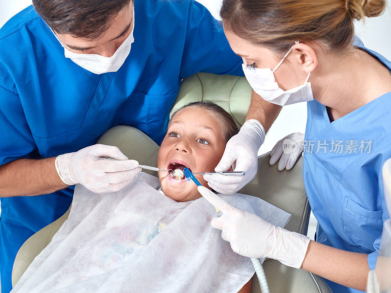 牙医和助理检查小女孩的牙齿