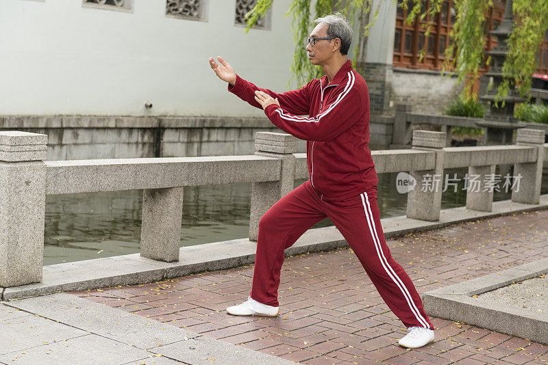 成熟的中国男子在公园里练习太极拳