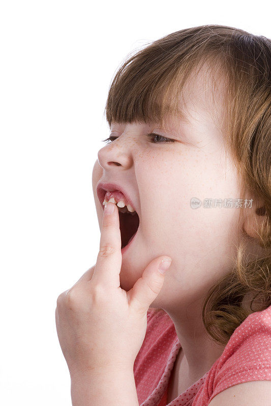 小女孩摆动着一颗松动的牙齿