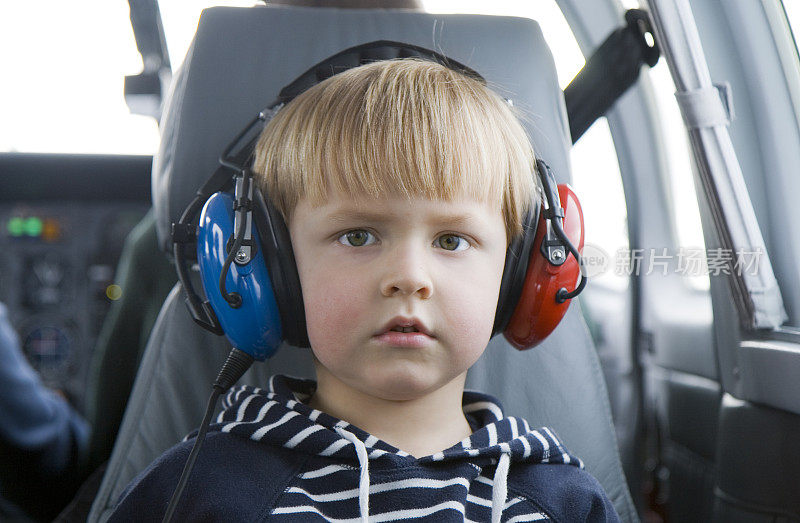 戴着耳机坐在私人飞机上的孩子