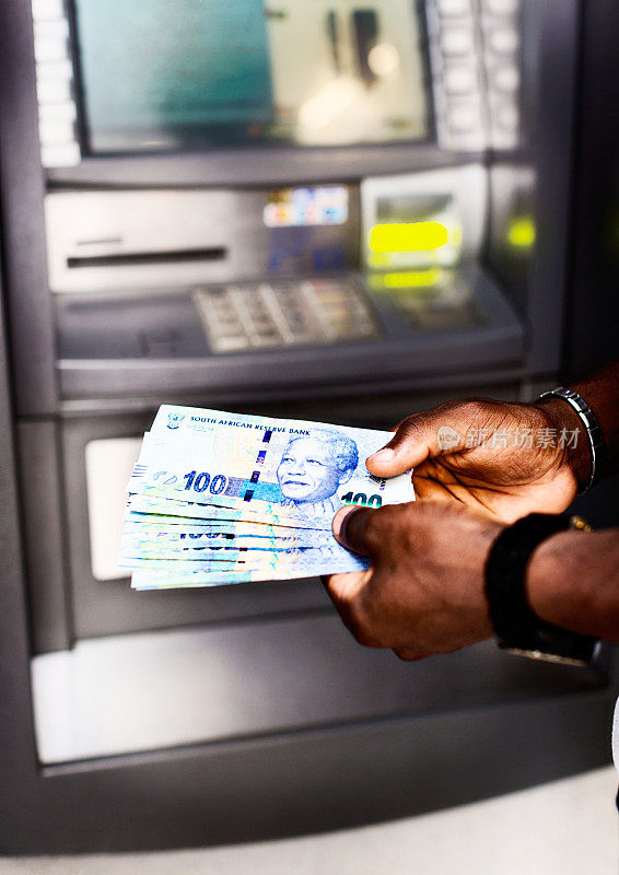 男性从自动取款机中取出南非百兰特钞票