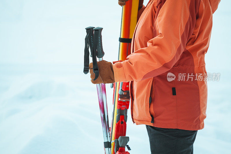 成熟的女人站着，拿着滑雪板