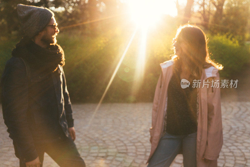 日落时分，一名男子和一名女子在华沙Łazienki公园散步