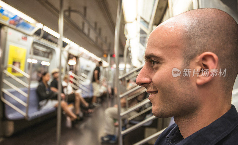 在纽约地铁列车上微笑的男人