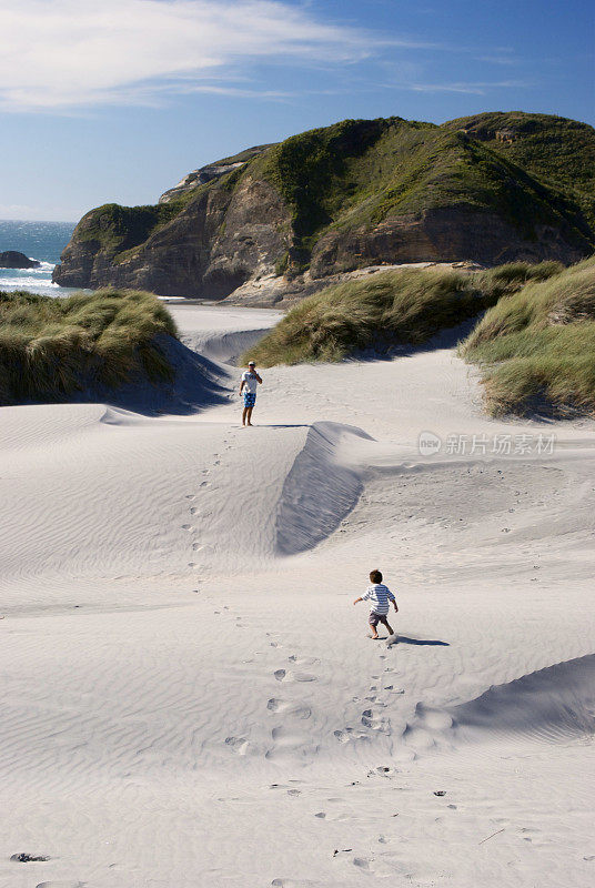 新西兰瓦拉里基海滩沙丘上的男人和孩子