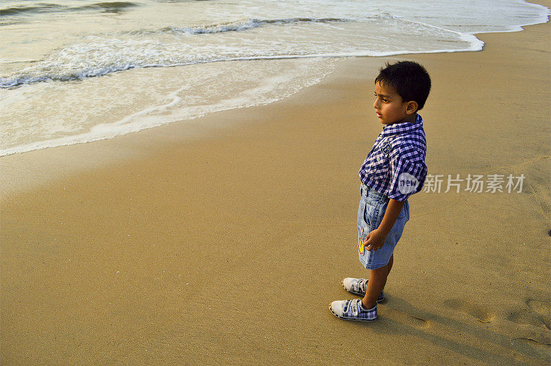 小男孩站在沙子里