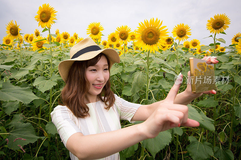 年轻女子在向日葵地里自拍