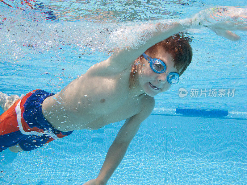 男孩自由泳在游泳池水下视图