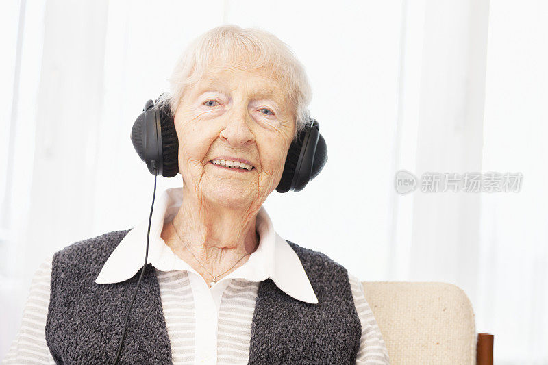 老妇人戴着耳机微笑着