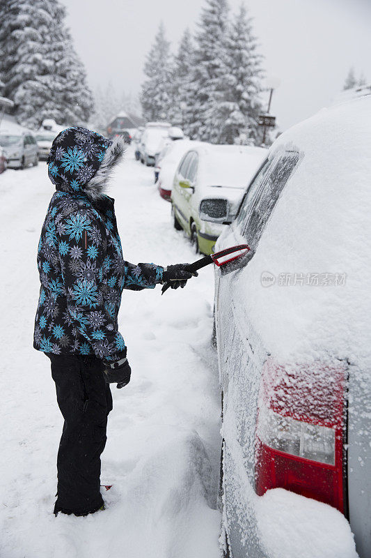 一个女人在擦车上的雪