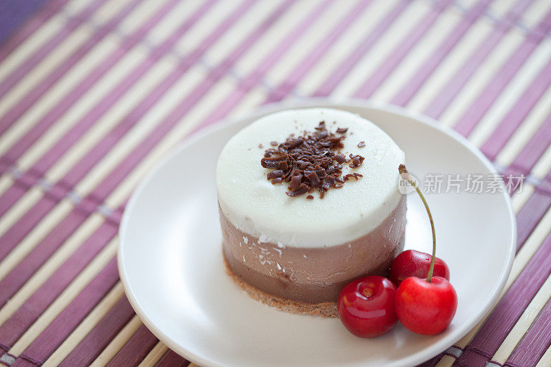 美味的小巧克力条纹奶油蛋糕和樱桃盘