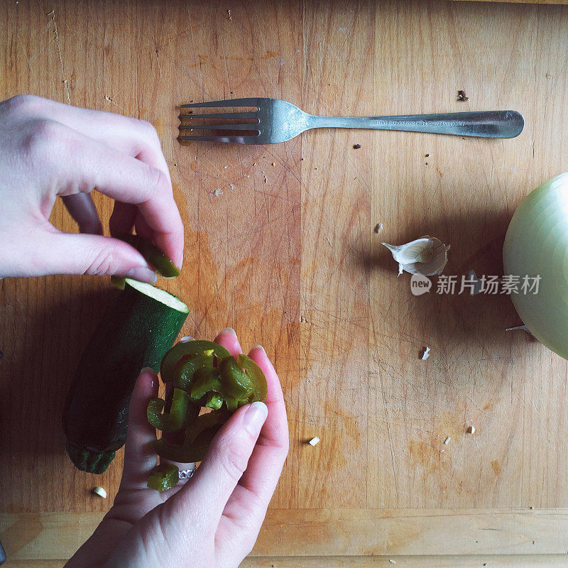 手在木砧板上切菜