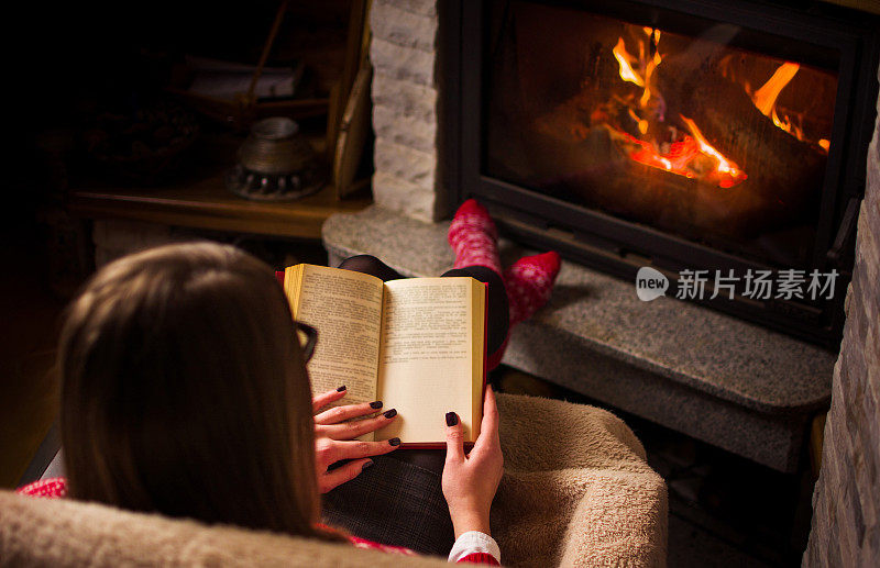 一个女人在壁炉边看书