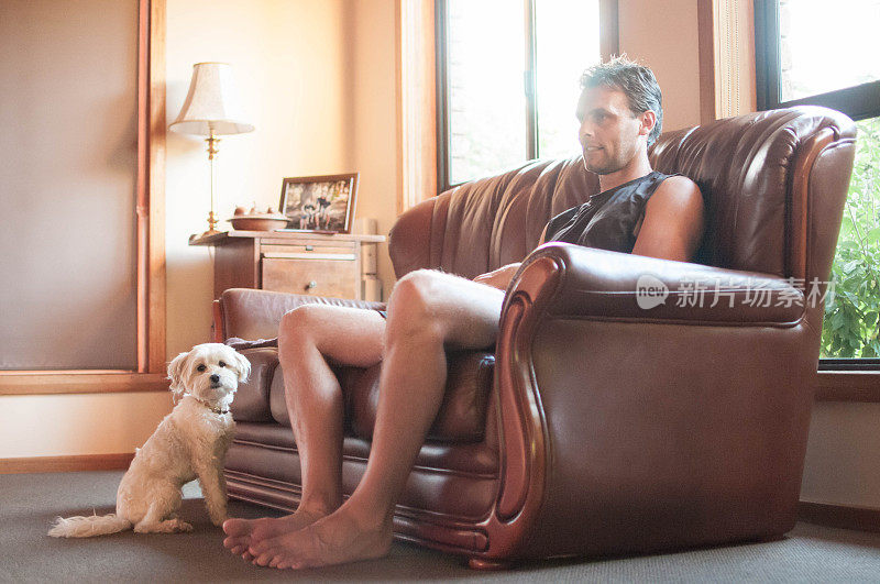 一个男人和他的宠物马尔济斯坐在客厅里