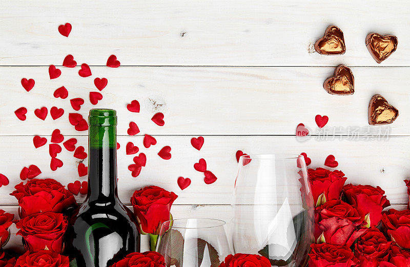 桌上有红玫瑰和酒