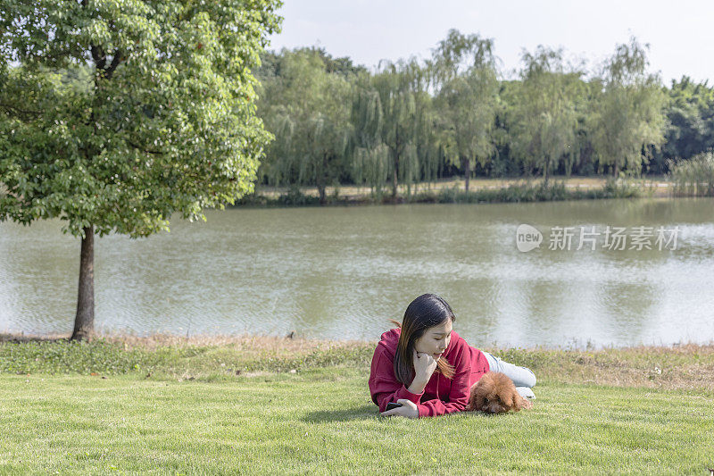 一个女人和她的小狗在湖边玩耍