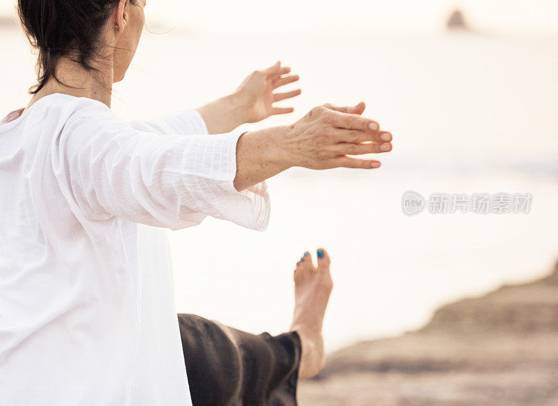 中身镜头女子练习传统吴式太极拳金色日落云景在她身后