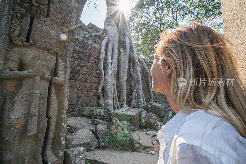 金发年轻女性白种人沉思古庙，旅游发现冒险概念在热带度假;金发游客女性参观古老的废墟